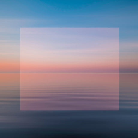 SUNSET: A photograph capturing the beauty of a calm ocean surface with a serene pink sunset in the background. The image is blurred, creating a dreamy and ethereal atmosphere. The soft, pastel colors of the sunset are reflected in the water, creating a sense of peace and tranquility.