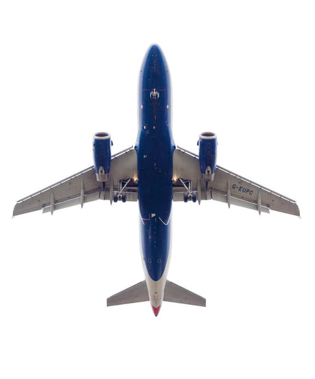 PLANE 301: A blue and white airplane with its landing gear down takes off against a clear sky. The airplane is photographed from directly below, offering a unique perspective. The tail of the airplane is visible, as well as the underside of its wings.