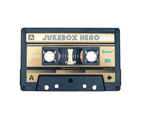 JUKEBOX HERO: A close-up image of a vintage cassette tape featuring a golden label with the text Jukebox Hero printed on it. The cassette tape has a black plastic casing and is in excellent condition.