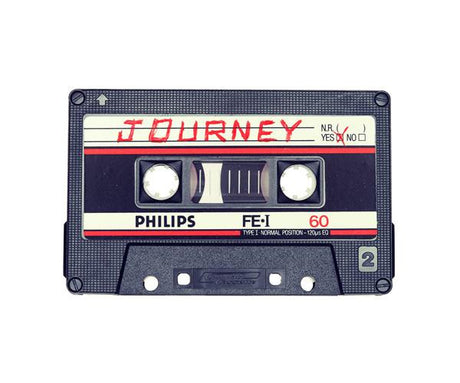 JOURNEY: This image shows a classic audio cassette tape featuring the band Journey. The tape is labeled as Philips and has a 60-minute duration. It is a black cassette with white and red labels, giving it a classic vintage look.