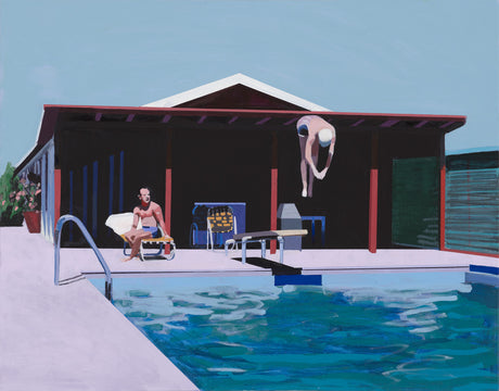 DEEP DIVE: A man wearing a bathing cap dives into a swimming pool from a diving board. The pool is located in a backyard, surrounded by a house with a shaded patio. Another man sits on a lounge chair next to the pool, watching the diver. The bright, sunny day suggests a relaxing summer afternoon.