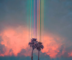 UNICORNS BEHIND BARS: This image features two palm trees silhouetted against a vibrant sunset sky. A digital rain of colorful vertical lines descends from the top of the frame, creating a surreal and abstract effect. The image evokes a sense of tranquility and the beauty of nature.