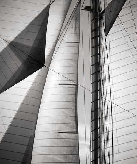 SAILS II COTE D'AZUR: This is a black and white photograph capturing a close-up view of a sailboat mast and sails. The image focuses on the intricate details of the rigging and sails, showcasing the lines and patterns created by the fabric.