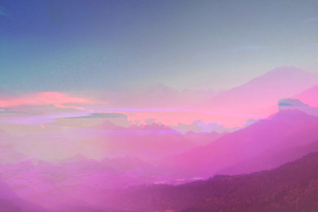 DISSOLUTION II: A scenic view of purple and pink clouds at sunset, casting a soft glow over a distant mountain range. The sky is a gradient of blue and pink, with a few wispy clouds visible.