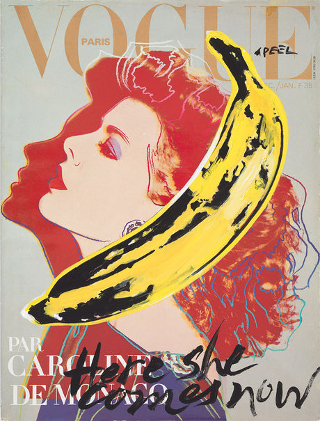 THE BANANA ISSUE: A close-up of the cover of the April 1985 issue of French Vogue, featuring a pop-art style illustration of a womanâ€™s face with red hair, by Andy Warhol. The womanâ€™s face is obscured by a large yellow banana with black stripes, a signature element of Warholâ€™s style. The word â€œPeelâ€ is handwritten in the corner of the image, encouraging viewers to interact with the cover.