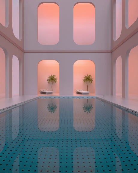 DAYDREAM 03: An indoor swimming pool with a bright blue tiled floor and a reflective surface. The pool is surrounded by white walls with arched windows that let in light, creating a soft pink glow. Two palm trees are visible outside the windows, their reflections visible in the water.