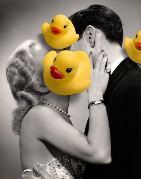 PATHOS: A romantic black and white photo of a couple embracing, their faces obscured by yellow rubber ducks. The man is in a suit and the woman is in a sparkly dress.