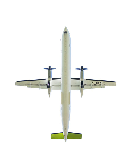 PLANE 50: A white passenger plane with a green tail sits on the ground in the daytime. The plane is facing directly up, so the viewer is looking at the underside of the plane. The plane is surrounded by a white background.