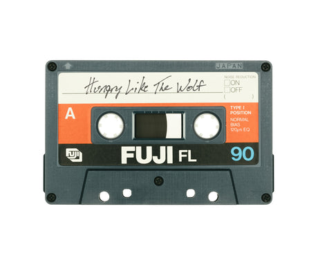 HUNGRY LIKE THE WOLF: An audio cassette tape labeled Hungry Like The Wolf in handwritten text. The tape is a Fuji FL 90, made in Japan. It is a standard compact cassette, with a black plastic shell and orange label.