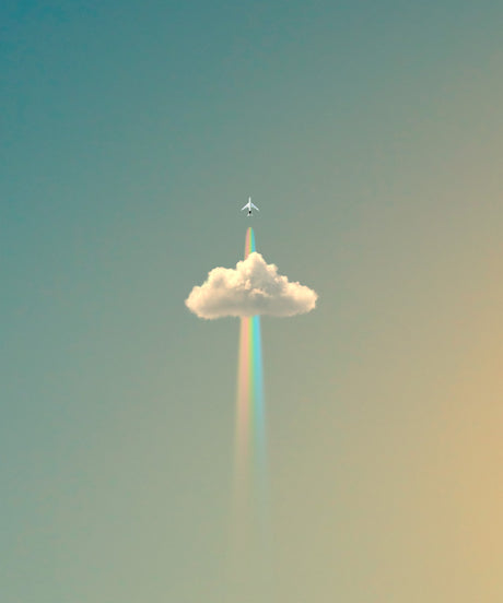 RAINBOW FLIGHT: An airplane flies through a single cloud in a clear, blue sky, leaving behind a rainbow-colored trail of condensation. The image is simple and minimalist, with a soft, vintage color palette.