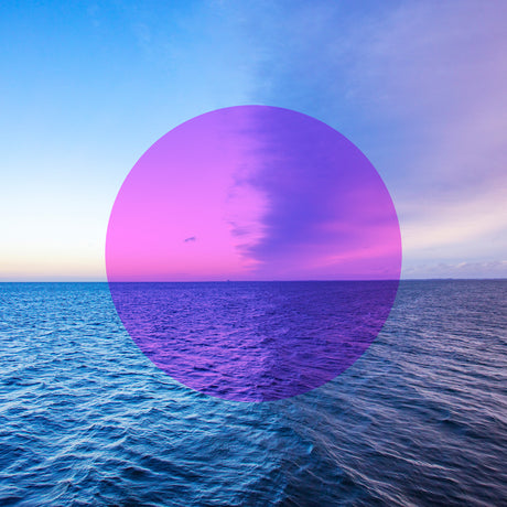 AFTER RAIN: A serene image featuring a calm ocean, with a purple-hued sunset appearing through a circular overlay, creating a unique and artistic representation of natures beauty.