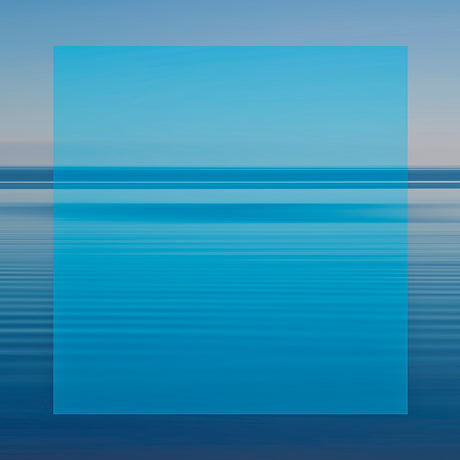 BLUE SQUARE AND SEASCAPE: A vibrant blue sky is reflected in the still waters of a calm ocean, creating a beautiful abstract pattern of lines. The serene scene is captured during the day, showcasing the tranquility of the natural environment.