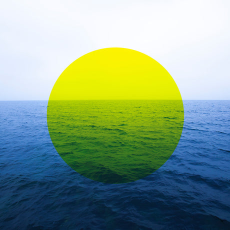 YELLOW CIRCLE AND SEA: A photo of a yellow circle over a blue ocean. The circle is superimposed over the water, and it appears to be a digital design. The background is a light blue sky.