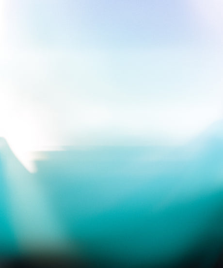 RIPPLE: A soft, blurred image of a blue and white gradient, resembling the sky and ocean. The background is out of focus, creating a smooth, calming effect. The image has a dreamlike and ethereal quality, making it perfect for design projects that require a subtle and serene aesthetic.