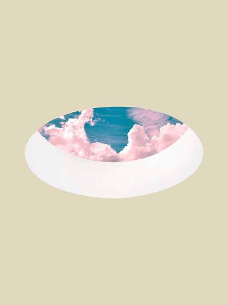 TO THE SKY: The image shows a white oval frame, like a window or a door, that frames a bright blue sky with fluffy pink clouds. The frame is situated against a pale green background, making it stand out.