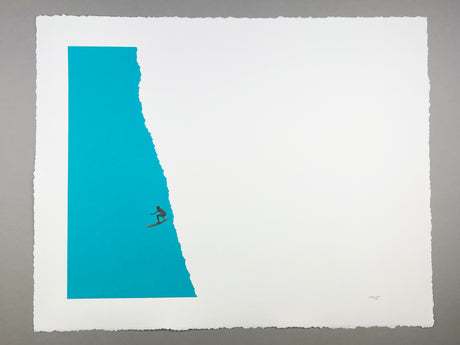 breaker: A minimalist print featuring a single surfer riding a wave inside a torn paper shape. The blue wave contrasts sharply against the white paper background, creating a striking visual. The surfer is a small silhouette, emphasizing the vastness of the ocean and the power of nature.